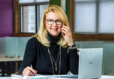 A female agent is calling a lead on her cellphone.