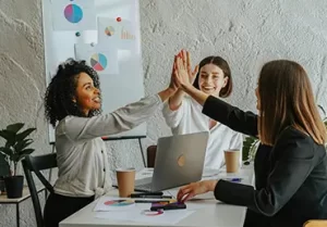 Office workers celebrate with a high five.